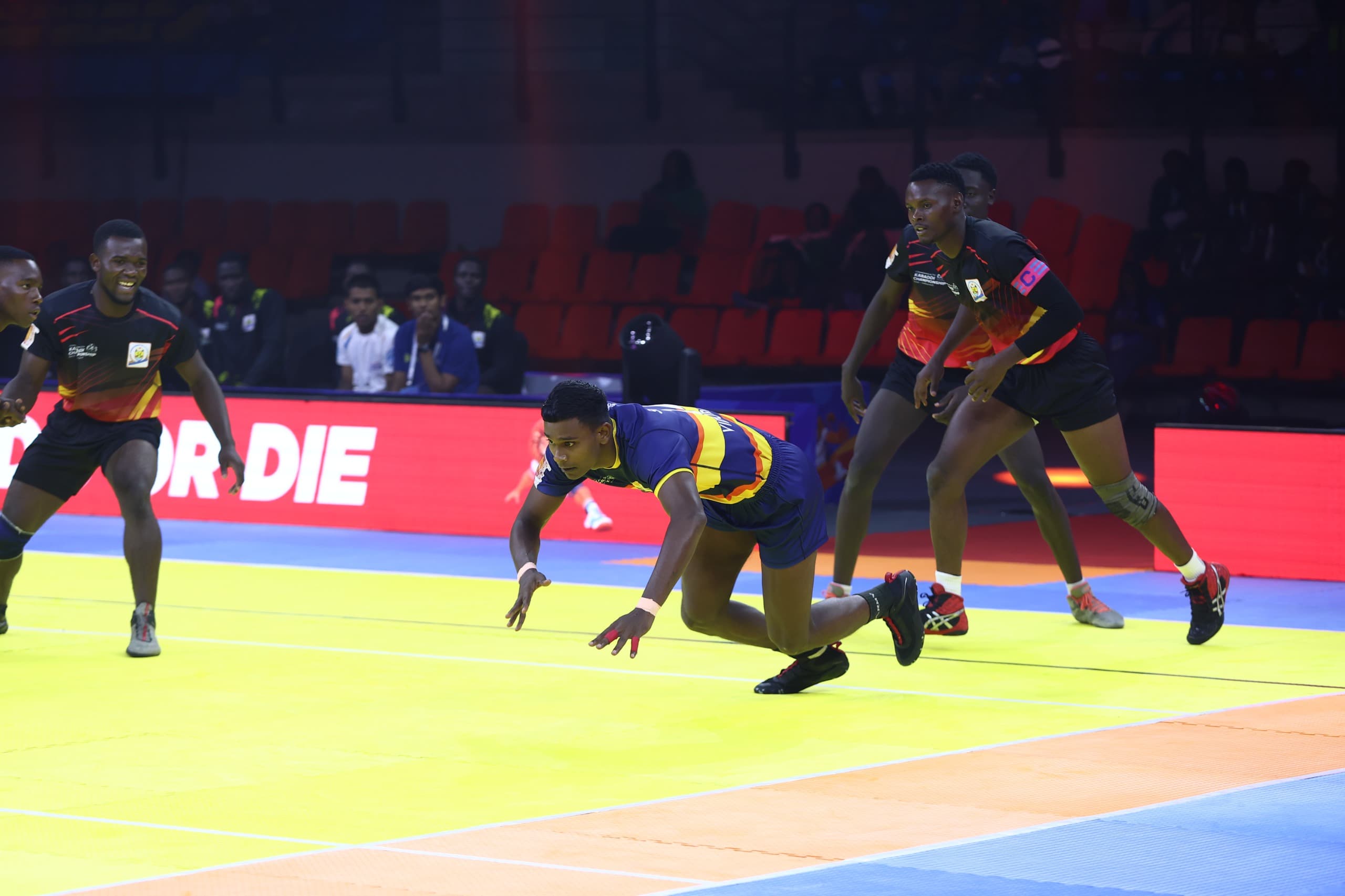 A Sri Lanka raider dives back to safety against Uganda at the Commonwealth Kabaddi Championship in Ahmedabad