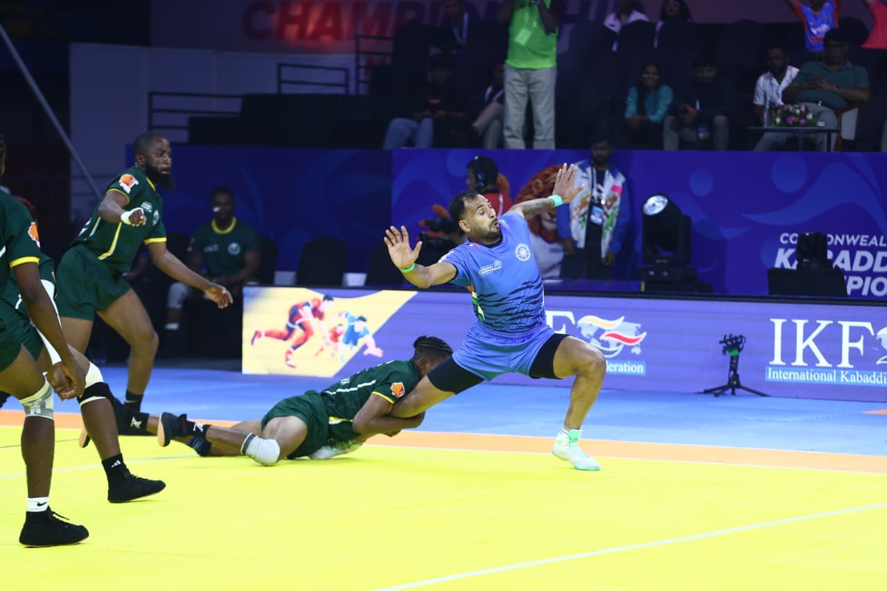 An India raider breaks free of a Nigeria defender's ankle hold at the Commonwealth Kabaddi Championship in Ahmedabad