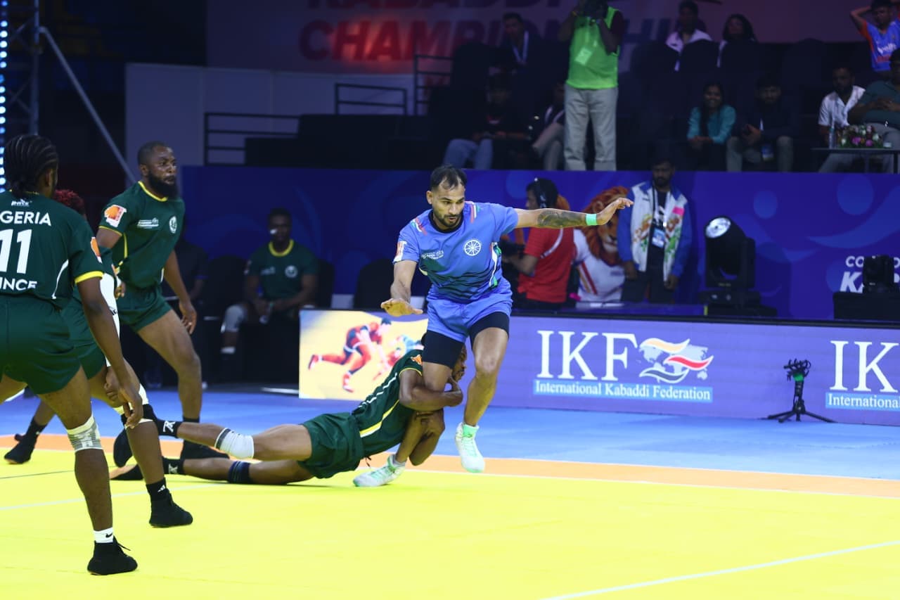 A Nigeria defender dives to tackle an India raider in the men's match in Ahmedabad
